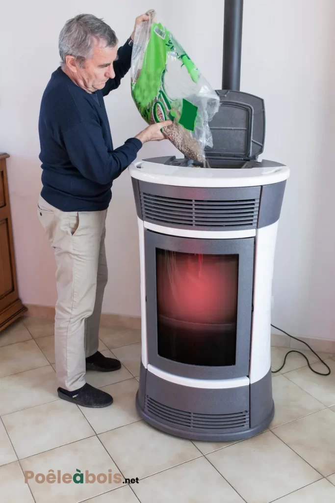 Un homme remplit un poêle à granules.